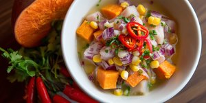 Peruvian ceviche garnished with sweet potato, corn and chili peppers