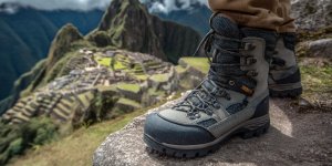 Professional trekking boots with gaiters on ancient Inca stone steps at Machu Picchu with detailed view of hiking gear and mountain trail equipment