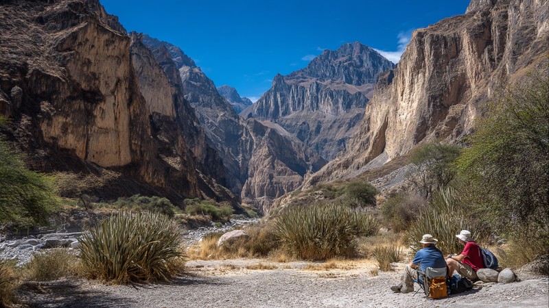 Hikers resting at an oasis inside the Colca Canyon with tall cliffs above