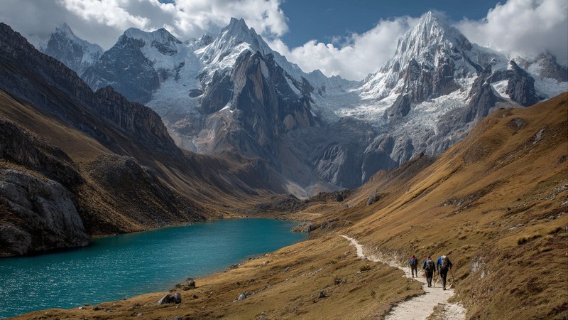 Trekkers following a glacial path through the Cordillera Huayhuash with towering peaks and turquoise lakes