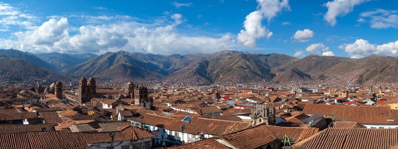 A panorama of Cusco’s red roofs with the Andes mountains in the background