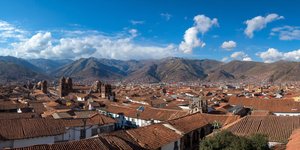 A panorama of Cusco’s red roofs with the Andes mountains in the background