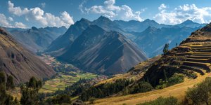 Panoramic view of Sacred Valley with terraced mountains, ancient Inca ruins of Pisac overlooking the green valley with traditional Andean villages below