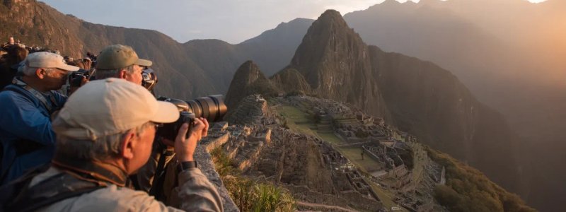 Photography enthusiasts capturing golden hour light at Machu Picchu with professional cameras, using wide-angle lenses to frame ancient terraces against dramatic mountain backdrops, and waiting for perfect sunrise conditions