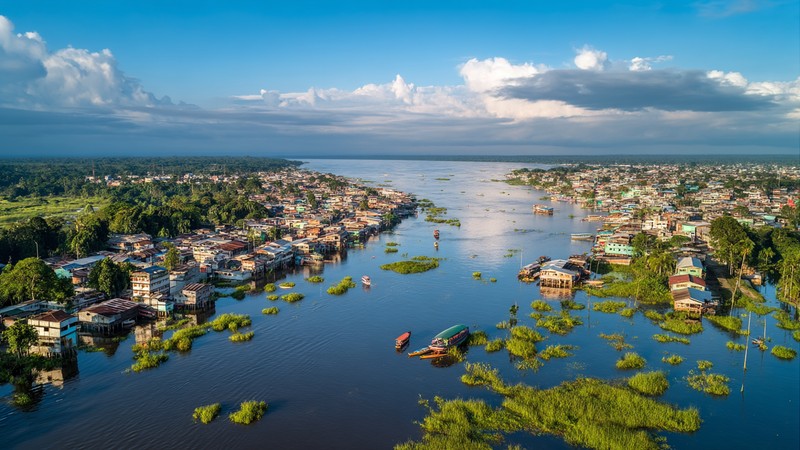 Aerial view of Iquitos city alongside the Amazon River with jungle in the distance