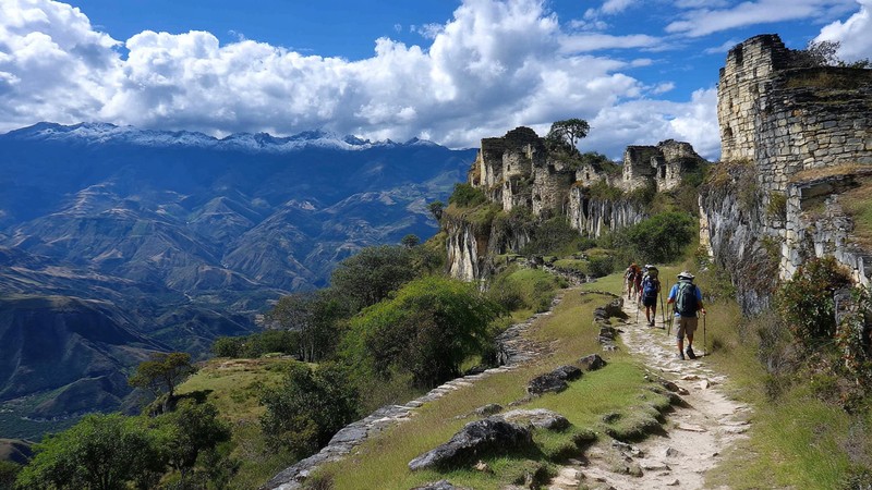 Hikers exploring Kuelap Fortress Hike with dramatic mountain scenery