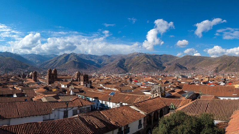 A panorama of Cusco’s red roofs with the Andes mountains in the background