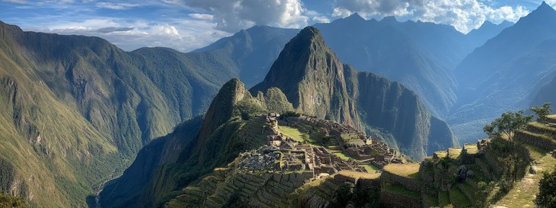 Panoramic view of Machu Picchu perched on a mountain ridge with Huayna Picchu in the background
