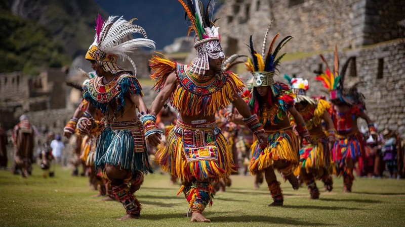 Cultural festivals around Machu Picchu featuring traditional Andean music and dance performances, colorful indigenous costumes, ancient ceremonies at archaeological sites, local artisans displaying crafts, and community celebrations with mountain backdrops