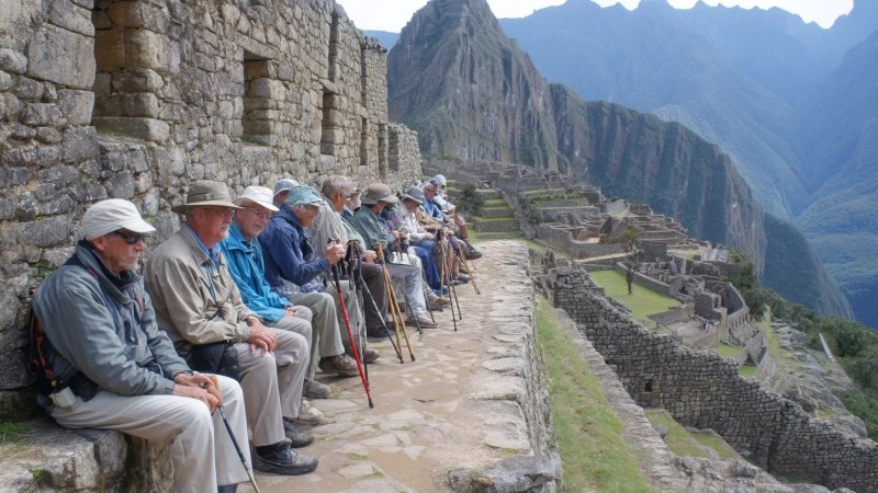 Senior travelers aged 60+ enjoying Machu Picchu with comfortable transportation, walking at a relaxed pace, using walking sticks, sitting on benches while admiring views, and participating in age-appropriate activities with professional guide assistance