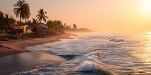 Golden sunset over Máncora’s wide sandy beach with surfers and palm trees