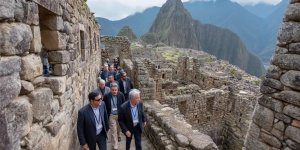 Business professionals visiting Machu Picchu during corporate retreats, wearing business attire while exploring ancient ruins, participating in team building activities, and balancing work responsibilities with cultural experiences