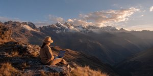 Person working remotely on a laptop overlooking the Peruvian mountains