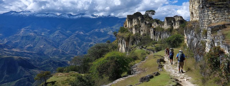 Hikers exploring Kuelap Fortress Hike with dramatic mountain scenery