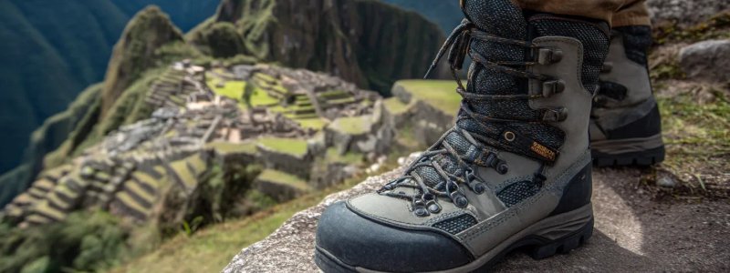Professional trekking boots with gaiters on ancient Inca stone steps at Machu Picchu with detailed view of hiking gear and mountain trail equipment