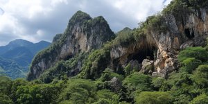 Jungle-clad limestone hills and the mouth of Cueva de las Lechuzas in Tingo María National Park
