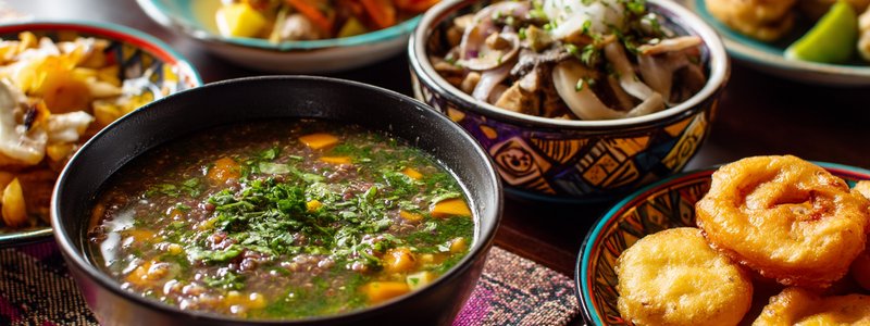 Colorful vegan Peruvian dishes including quinoa soup, mushroom ceviche and picarones on a table