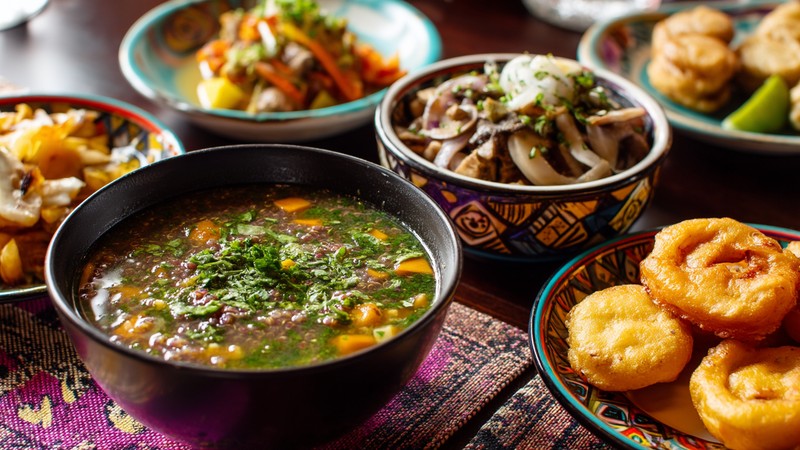 Colorful vegan Peruvian dishes including quinoa soup, mushroom ceviche and picarones on a table
