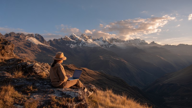 Person working remotely on a laptop overlooking the Peruvian mountains